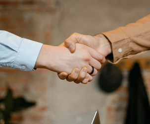 Close-up of a handshake symbolising Häcker’s commitment to customer service and reliable support beyond the product