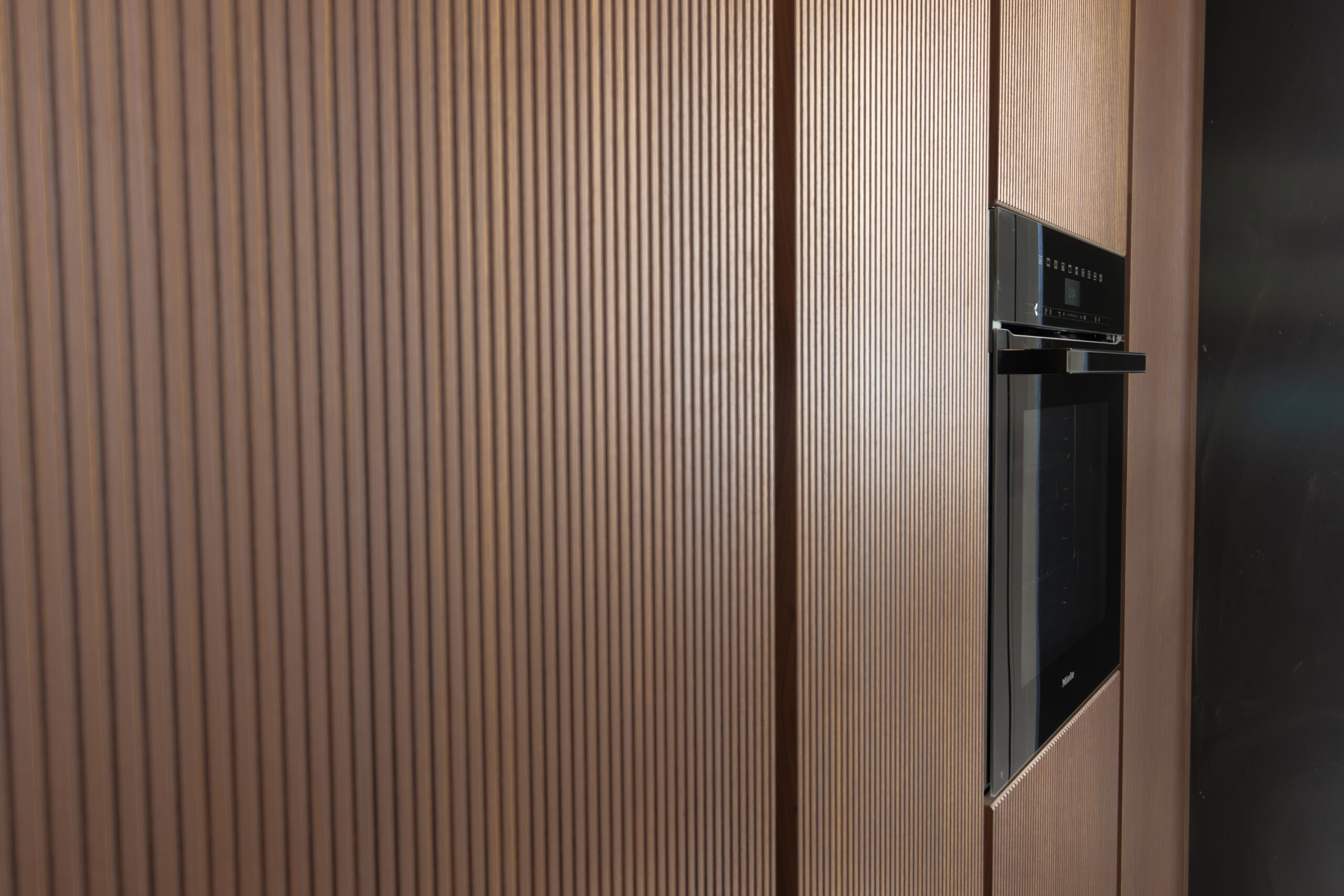 Vertical timber kitchen panels with built-in black oven